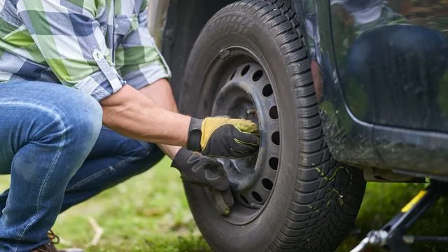 Dc auto care's mechanic performing on-site tire replacement